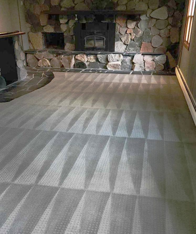 Clean carpet with vacuum lines running up to a stone fireplace