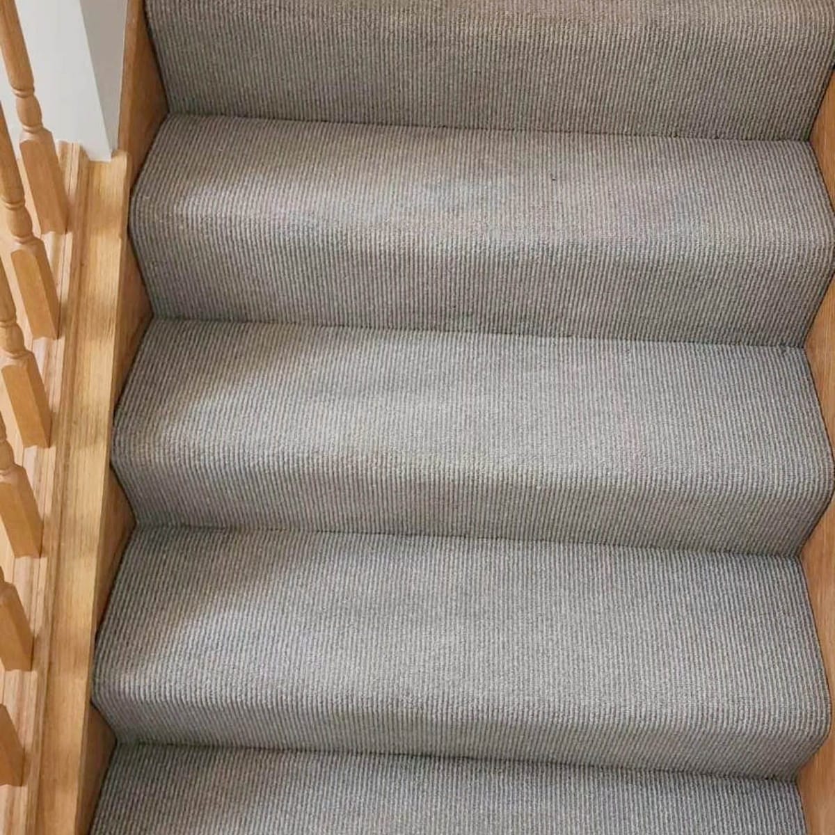 Cleaned carpeted stairs between wood trim